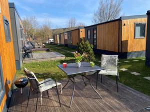 a table and chairs on a deck with a tiny house at Holiday Home Motte by Interhome in Wemding
