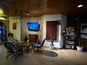 a living room with a table and chairs and a tv at Han Dalyan Hotel in Dalyan