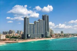 アジュマーンにあるCMA Skyline Sanctuary Apartments - Ajman Corniche UAEの高層ビルと海の景色を望むビーチの景色を望む客室です。