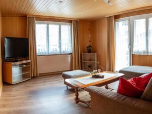 een woonkamer met een bank en een tv bij Apartment Bergfreude by Interhome in Saas-Grund
