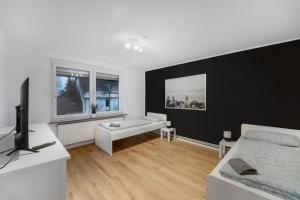 Biały salon z kanapą i telewizorem w obiekcie Moderne Wohnung mit Garten & Küche w mieście Celle