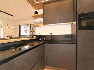 Una cocina con gabinetes grises y un fregadero. en Apartment Christine by Interhome, en Brixlegg