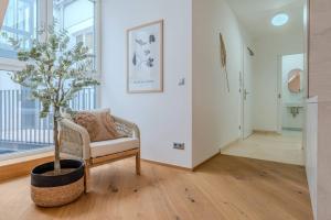 een woonkamer met een stoel en een potboom bij Neustift Deluxe in Wenen