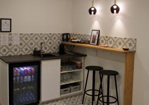 a bar with two stools and a counter with drinks at VALOLA Boutique Rooms in Valencia