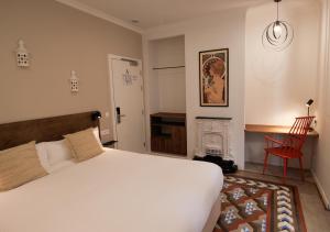 a bedroom with a white bed and a fireplace at VALOLA Boutique Rooms in Valencia