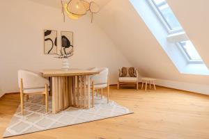 a dining room with a table and chairs in a attic at Neustift Deluxe in Vienna