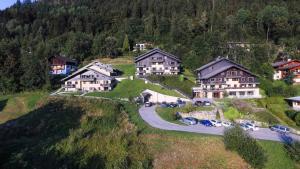 un gruppo di case su una collina con auto parcheggiate di Résidence Les Fermes De Saint Gervais - 2 Pièces pour 6 Personnes 54 a Saint-Gervais-les-Bains