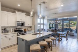 a kitchen with white cabinets and a table with chairs at Luxury At The Ledges in St. George