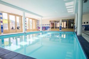 una piscina de agua azul en un edificio en Résidence Les Fermes De Saint Gervais - 2 Pièces pour 4 Personnes 87, en Saint-Gervais-les-Bains