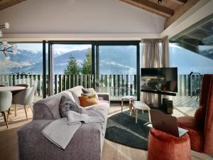 a living room with a couch and a tv and a laptop at Haus am Lift in Zell am See
