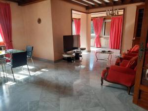 a living room with red chairs and a flat screen tv at Goutanou 01200 in Châtillon-de-Michaille