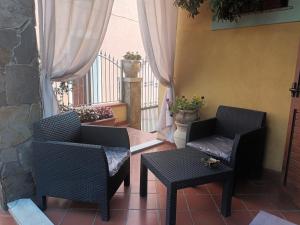 a patio with two chairs and a table and a balcony at Valentina's Garden House in Triei