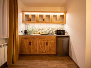 uma cozinha com armários de madeira e um lavatório em Sielski Zakątek em Zakopane