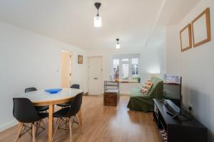 ein Wohnzimmer mit einem Tisch und ein Schlafzimmer in der Unterkunft Brand new one bedroom flat in Central London in London