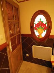 a bathroom with a stained glass window and a door at Les Bains Bed & Breakfast in Cheny