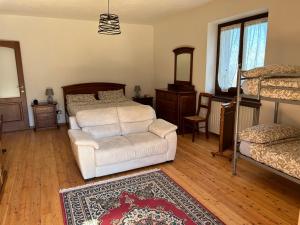 1 dormitorio con 1 cama, 1 silla y 1 alfombra en Casa Salada, en Bagnolo Piemonte
