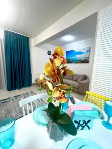普洛耶什蒂的住宿－Residence 3，一张桌子,上面有花瓶,上面有黄色花