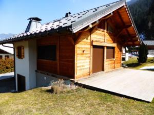a small wooden house with a large wooden deck at Chalet Champelet - Chalets pour 8 Personnes 33 in Les Contamines-Montjoie