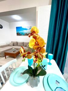 una mesa con un jarrón con flores amarillas. en Residence 3 en Ploieşti