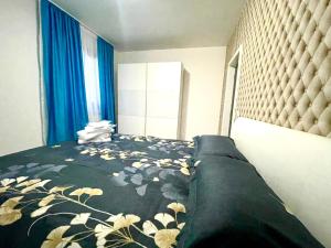 普洛耶什蒂的住宿－Residence 3，一间卧室配有一张带花卉床罩的床