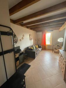 a living room with a couch and a table at La porte chamarrée... in Saint-Nicolas-de-la-Grave +24 photos