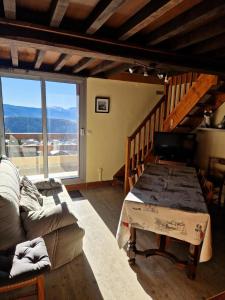 a living room with a table and a large window at Appartement 3 pièces 8 pers. calme - maeva Home - 3 Pièces 8 Personnes Selection MAE-3806 in Font Romeu Odeillo Via