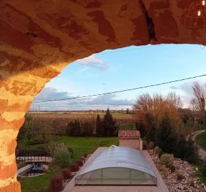 a view of a field and a tent from an archway at La porte chamarrée... in Saint-Nicolas-de-la-Grave
