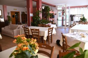 a restaurant with tables and chairs with flowers on them at B&B La Tenuta del Conte in Fermo