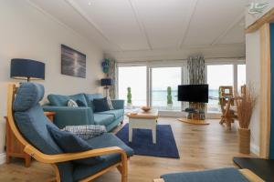 a living room with a blue couch and a tv at Higher Mount View in Marazion