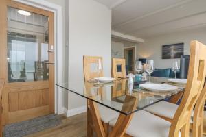 ein Esszimmer mit Glastisch und Stühlen in der Unterkunft Higher Mount View in Marazion + 29 Fotos
