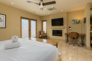 a bedroom with a bed and a desk and a fireplace at El Noa Noa in Palm Springs