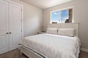 a white bedroom with a bed and a window at The Perfect Escape in Ivins +21 photos