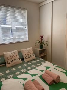 a bedroom with a bed with two pillows saying love grow at Stunning Flat Close to Regents Park and Euston Station! in London