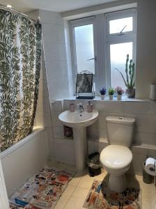 ein Bad mit einem WC, einem Waschbecken und einem Fenster in der Unterkunft Stunning Flat Close to Regents Park and Euston Station! in London