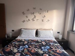 ein Schlafzimmer mit einem Bett mit Schmetterlingen an der Wand in der Unterkunft Casa Vacanze La Formica in Verbania