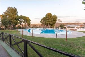 einen Pool in einem Garten mit einem Holzzaun in der Unterkunft Oasis en Riba Roja del Turia in Riba-roja de Túria