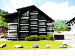 a black building with rocks in front of it at Résidence Le Brulaz - Studio pour 5 Personnes 50 in Les Contamines-Montjoie