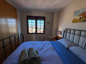 ein Schlafzimmer mit einem Bett mit blauen Laken und einem Fenster in der Unterkunft Oasis en Riba Roja del Turia in Riba-roja de Túria + 27 Fotos