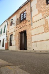 a brick building with a door on a street at casa rural Cieza de León in Llerena