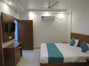 a bedroom with a bed and a television in it at The Namami Tapovan in Rishīkesh