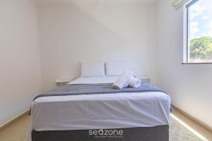 a bedroom with a bed with two towels on it at Aconchegante apartamento bem mobiliado PDM005 in Porto Seguro