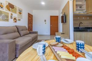 a living room with a couch and a table with cheese at Aconchegante apartamento bem mobiliado PDM005 in Porto Seguro