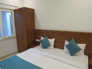 a bedroom with a bed with blue and white pillows at The Namami Tapovan in Rishīkesh