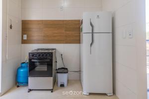 a kitchen with a refrigerator and a stove at Aconchegante apartamento bem mobiliado PDM005 in Porto Seguro