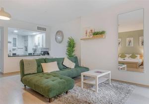 a living room with a green couch and a table at Spacious Studio in Murjan 2: Near the Beach in Dubai