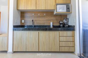 a kitchen with a sink and a microwave at Aconchegante apartamento bem mobiliado PDM005 in Porto Seguro