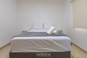 a bedroom with a bed with two towels on it at Aconchegante apartamento bem mobiliado PDM005 in Porto Seguro