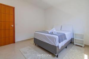 a bedroom with a bed and a dresser at Aconchegante apartamento bem mobiliado PDM005 in Porto Seguro