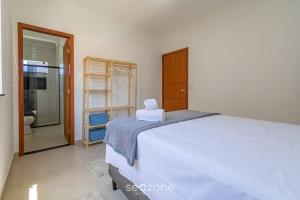 a bedroom with a large bed and a bathroom at Aconchegante apartamento bem mobiliado PDM005 in Porto Seguro