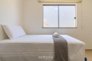 a bed in a room with a window at Aconchegante apartamento bem mobiliado PDM005 in Porto Seguro